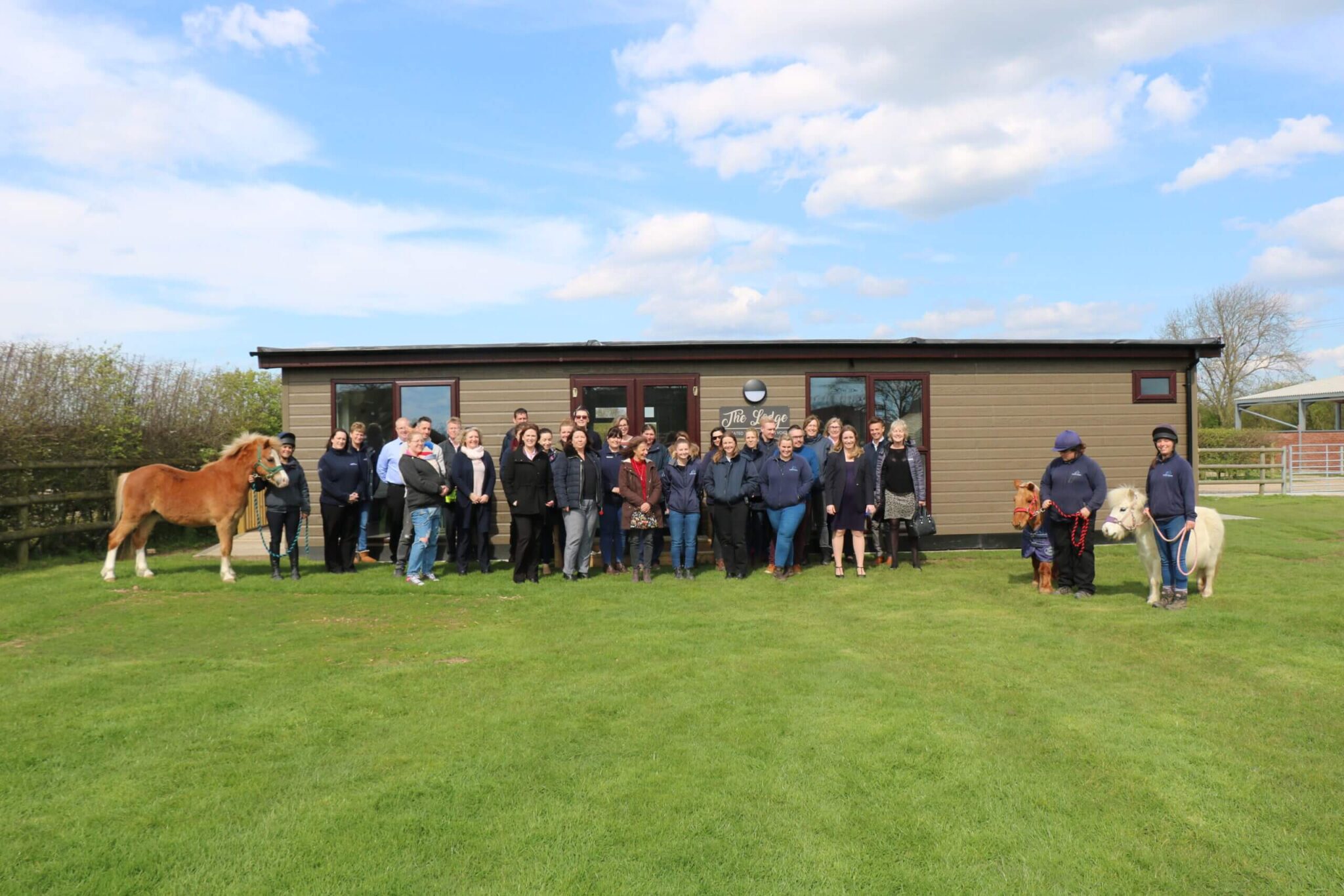 members of staff stood outside the newly built lodge