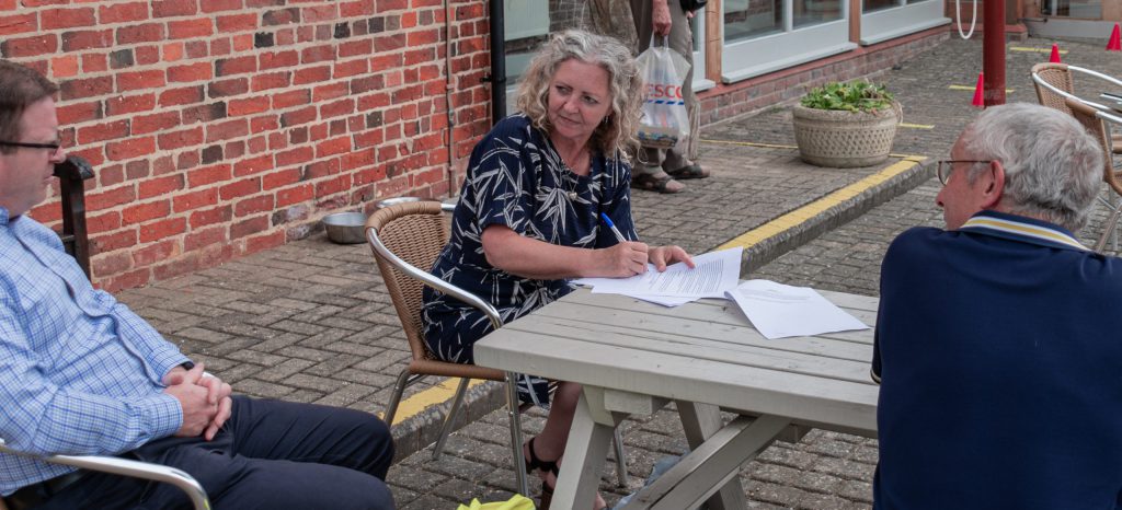 people sat at a bench in the bransby horses cafe courtyard