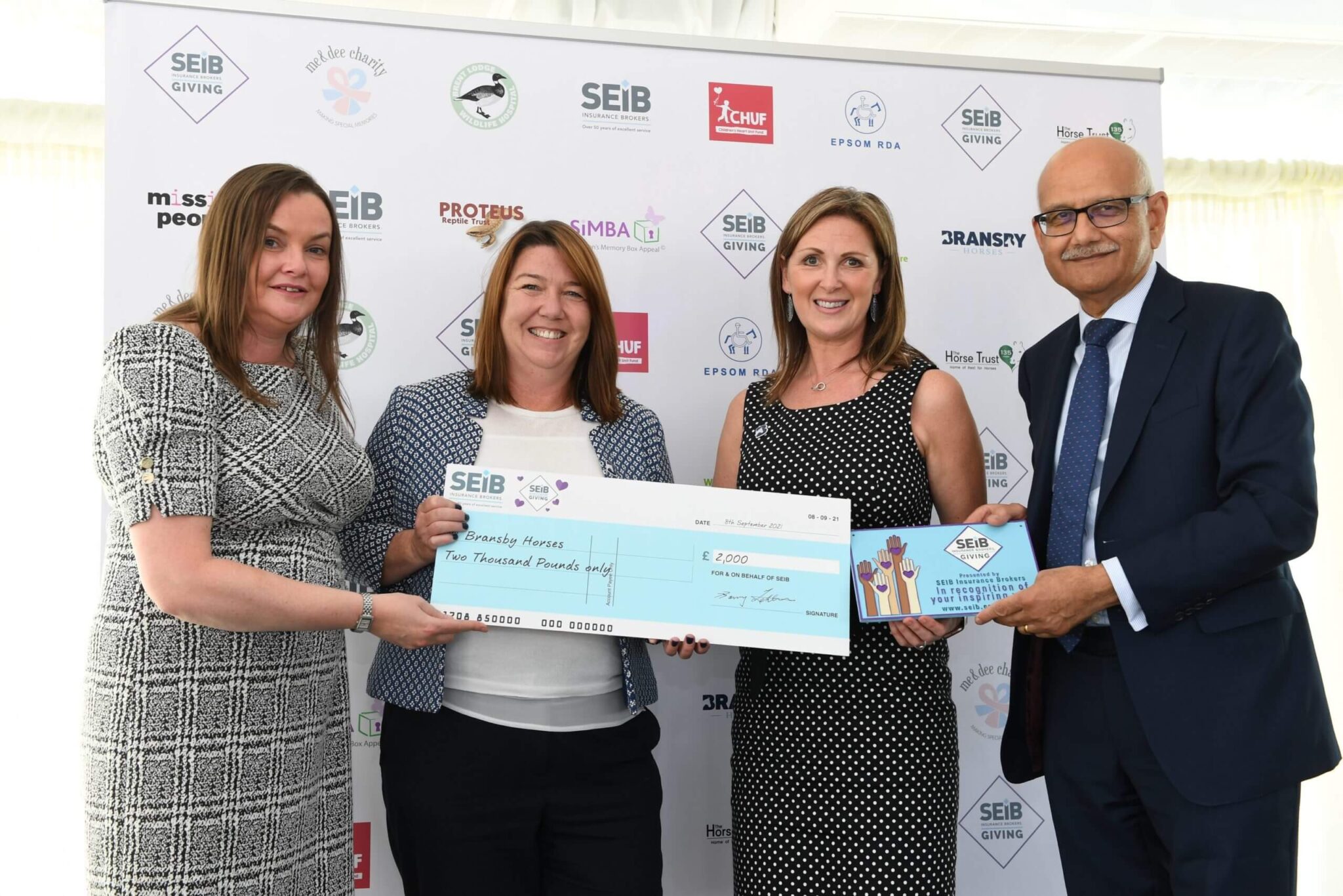 members of bransby horses staff being awarded with a check for two thousand pounds at the SEIB insurance brokers award