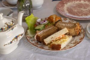 plate of sandwiches with salad and a small sausage roll