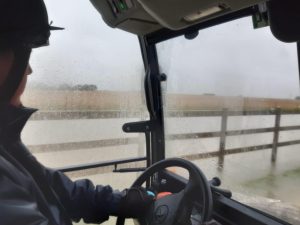 member of staff driving a buggy past flooded fields