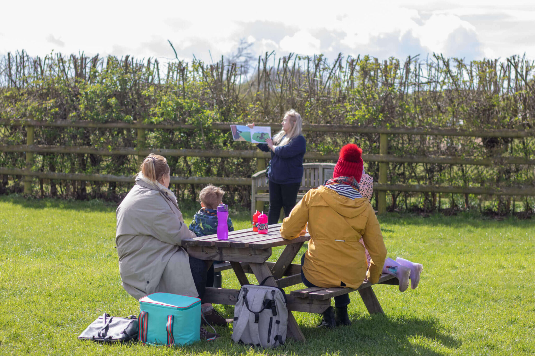 family sat outside on a picnic bench during the winter