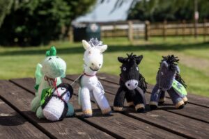 group of knitted horses and a dragon