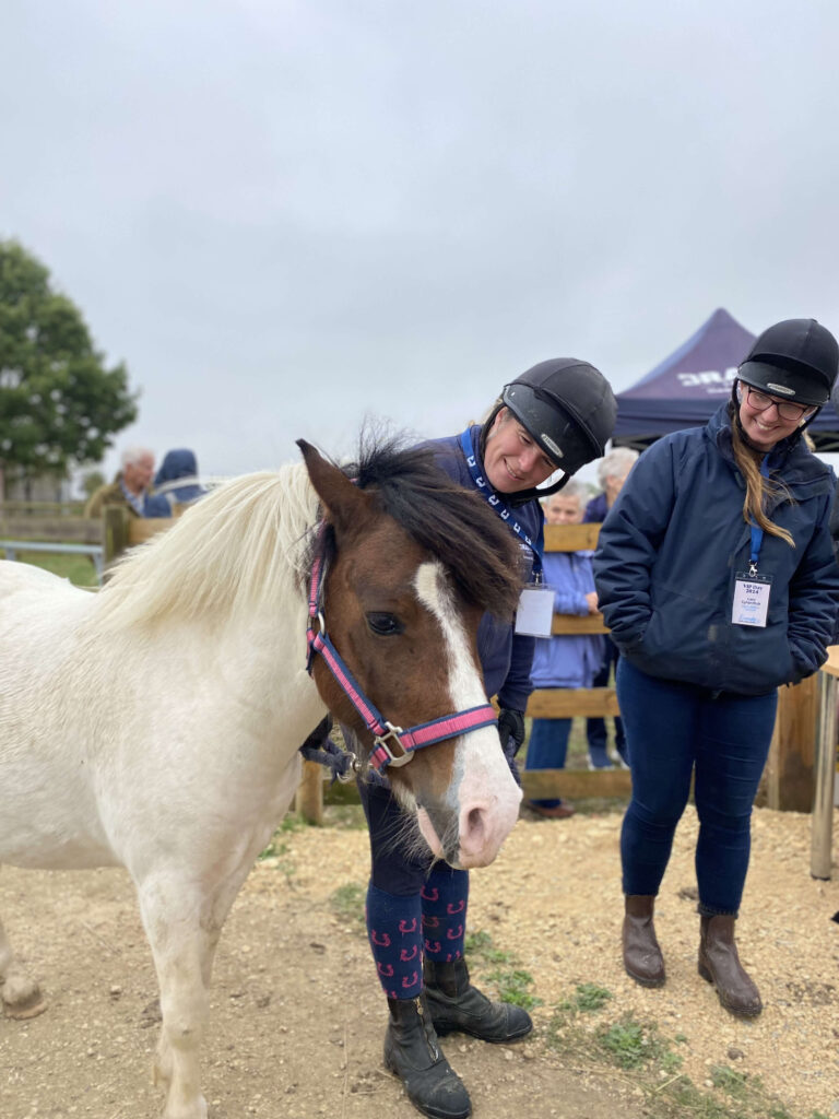 members of staff stood next to a white and brown cob