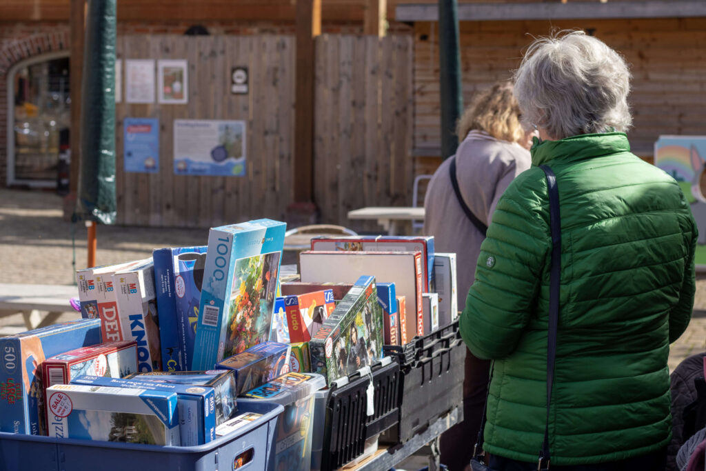 visitor wearing a green coat and browsing donated goods in the courtyard